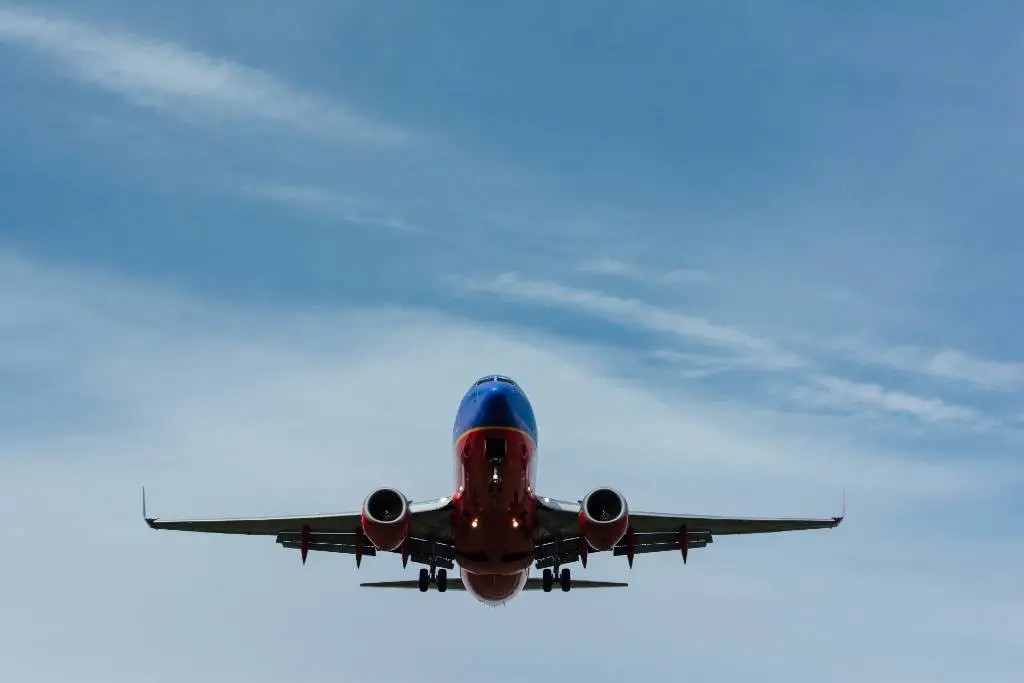 Southwest Airlines airplane in flight, highlighting its red and blue branding, against a clear sky, emphasizing the airline's recognizable livery and brand presence in the aviation industry.