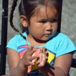 Young Indigenous girl in traditional clothing, representing Cree language and culture