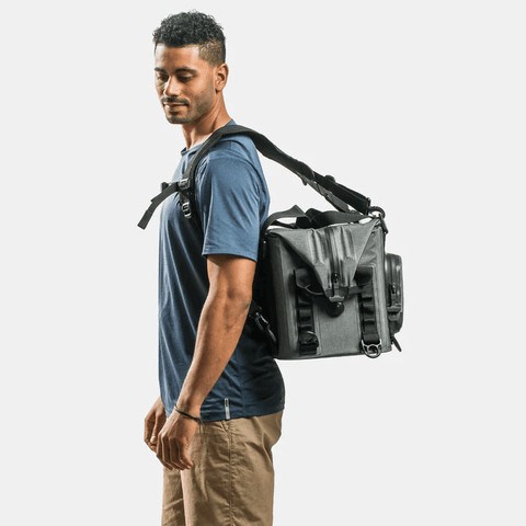 Young adult carrying a grey ICEMULE Traveler cooler