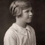 Black and white photo of a young girl with a spiral bun in her hair. Venetia Burney, the eleven-year-old girl who named Pluto, in a vintage portrait.