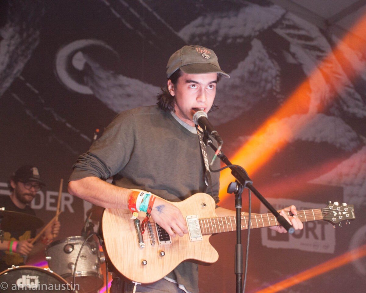 Alex G captivating his audience with an emotionally charged performance, embodying the raw feelings explored in songs like "I Wait For You" and the evocative phrase "nothing compares to the fever dream".