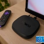 Roku Ultra 2024 on a wooden table with its remote control and a television in the background.