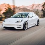 Full shot of a white Tesla car on the road