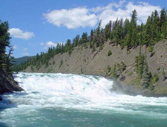 Snowmelt contributes a lot of water during spring in a river in Banff, Canada. Alt text: Banff River in springtime with snowmelt, Canada, illustrating river size and water volume.