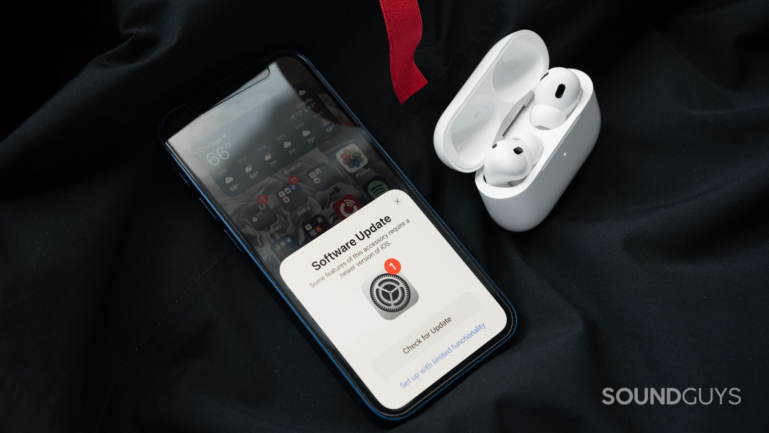 The Apple AirPods Pro (2nd generation) Case Is Open and Contains the Earbuds Next to an iPhone 12 Mini, Which Prompts the User to Update to iOS 16