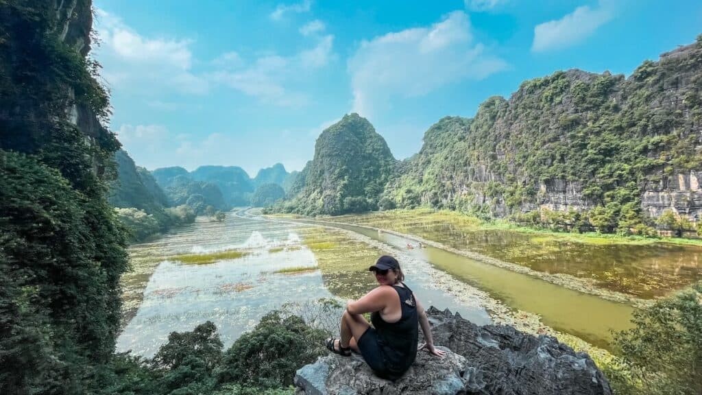 Taking a boat tour in Tam Coc, Vietnam is a must-do, showcasing the serene landscape with limestone cliffs surrounding the river.