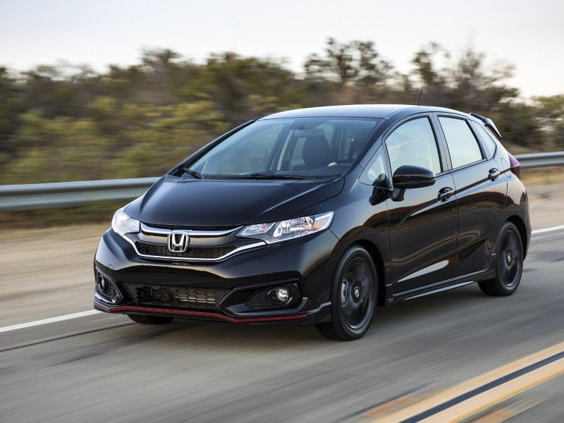 Honda Fit black driving on road