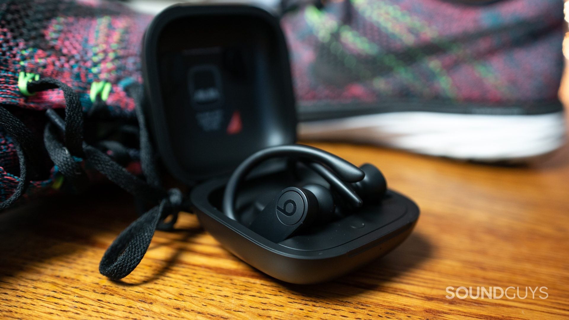 Powerbeats Pro Next to Running Sneakers Showcasing Gym Use