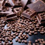 Dark organic chocolate and coffee beans on concrete background