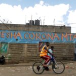 A man cycles past a wall mural advocating against the coronavirus disease (COVID-19) outbreak in Nairobi, Kenya April 11, 2020. REUTERS/Njeri Mwangi