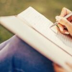 Woman writing in a gratitude journal, overcoming comparison.