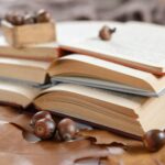 Stack of three open books on a wooden table