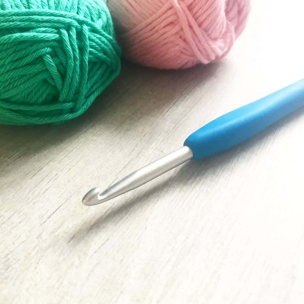 Pink and green cotton yarn and crochet hook