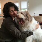 Suzana Herculano-Houzel with her dog, Mielina, illustrating the bond between humans and animals. The photo underscores the observation that even small dogs may have more neurons than cats, contributing to the broader discussion on animal intelligence.