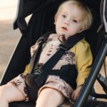A relaxed child in the Thule Urban Glide Two jogging stroller, highlighting its comfort and design.