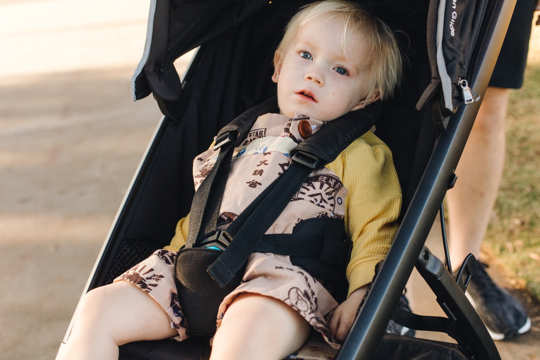 A relaxed child in the Thule Urban Glide Two jogging stroller, highlighting its comfort and design.