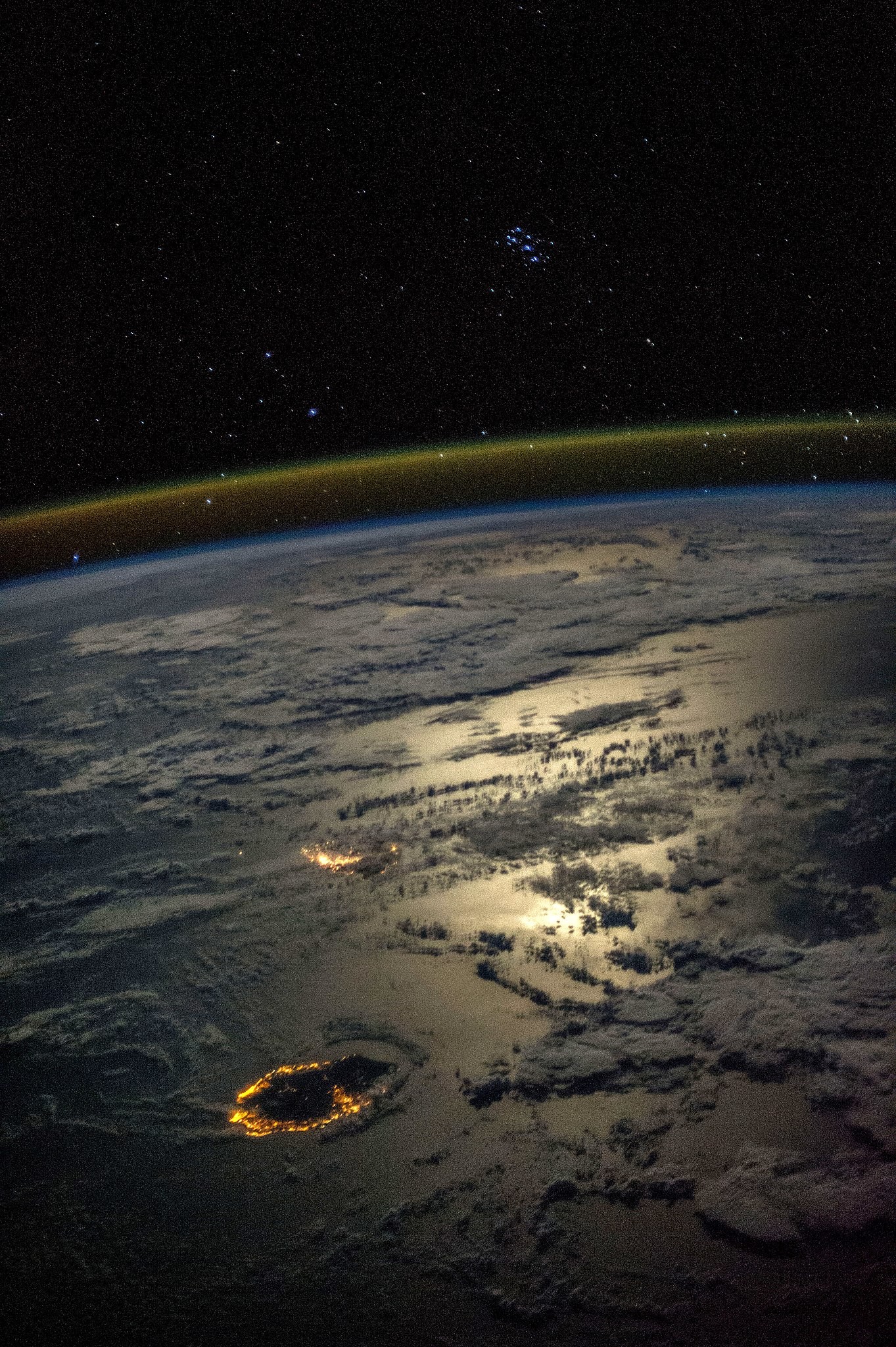 Astronaut Karen Nyberg's stunning image of Mauritius and Réunion at night from the ISS, highlighting the vastness of Earth compared to human scale, captured in 2013