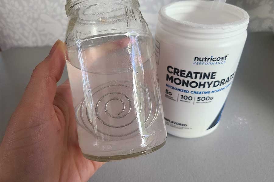Nutricost creatine powder mixed in a glass, showing its texture and consistency