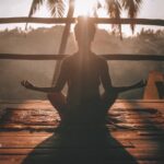 Woman practicing self-compassion by meditating in nature