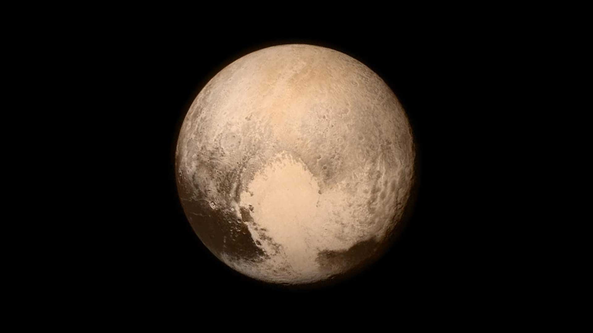Pluto is reddish and has a heart shape lighter patch in the lower right half of this image from the New Horizons spacecraft, the heart of Pluto.