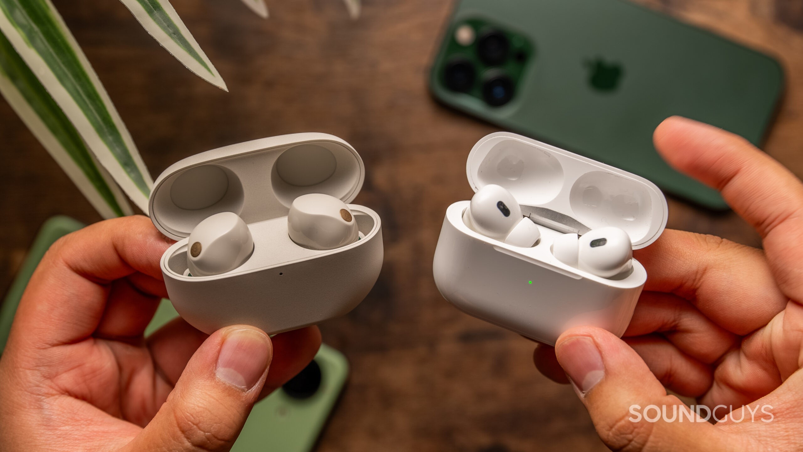 Sony WF-1000XM5 and Apple AirPods Pro 2 cases being held in hands